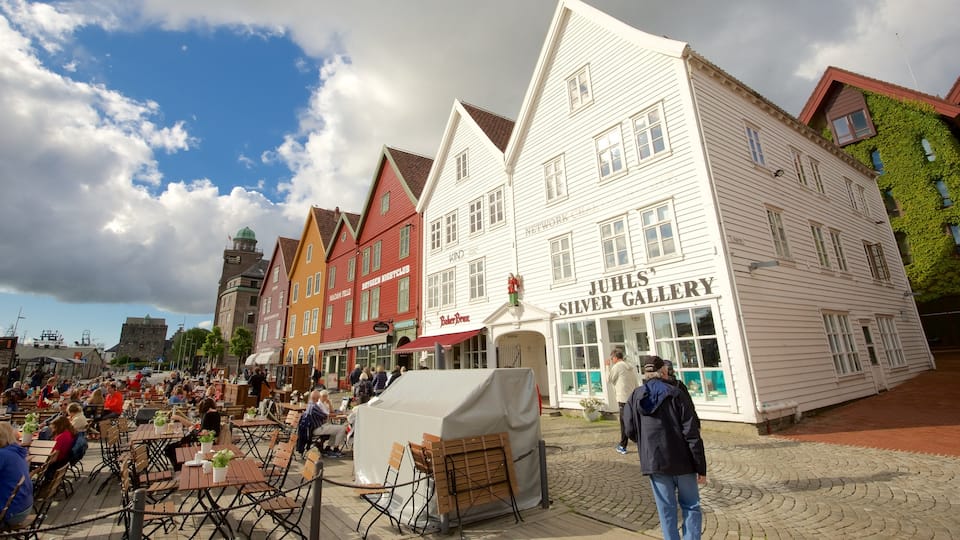 Bryggen which includes a small town or village and outdoor eating as well as a large group of people