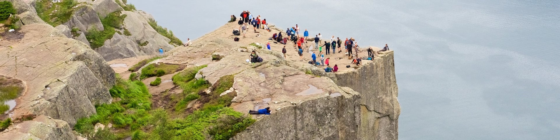 Preikestolen montrant lac ou étang et vues aussi bien que important groupe de personnes