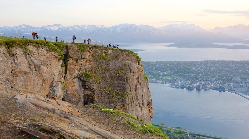 Tromso que incluye un lago o laguna, un atardecer y montañas