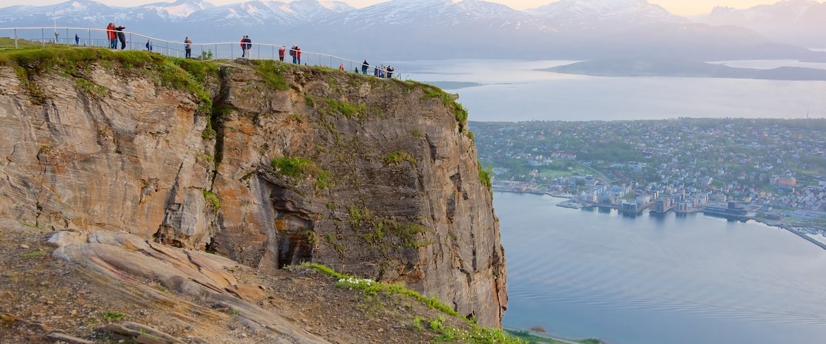Tromso mostrando una puesta de sol, montañas y un lago o abrevadero