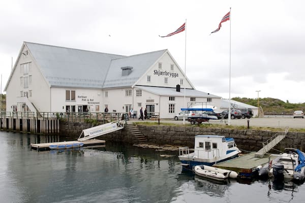 Hurtigruten Fähranleger Stamsund mit einem Bootfahren und Kleinstadt oder Dorf