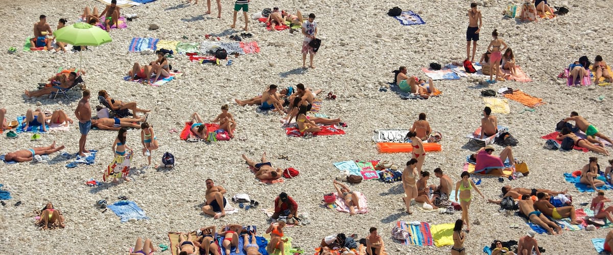 Polignano a Mare caratteristiche di spiaggia di ciottoli cosi come un grande gruppo di persone
