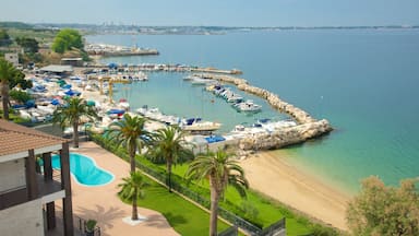 Taranto que incluye vistas de una costa, una playa de arena y una localidad costera