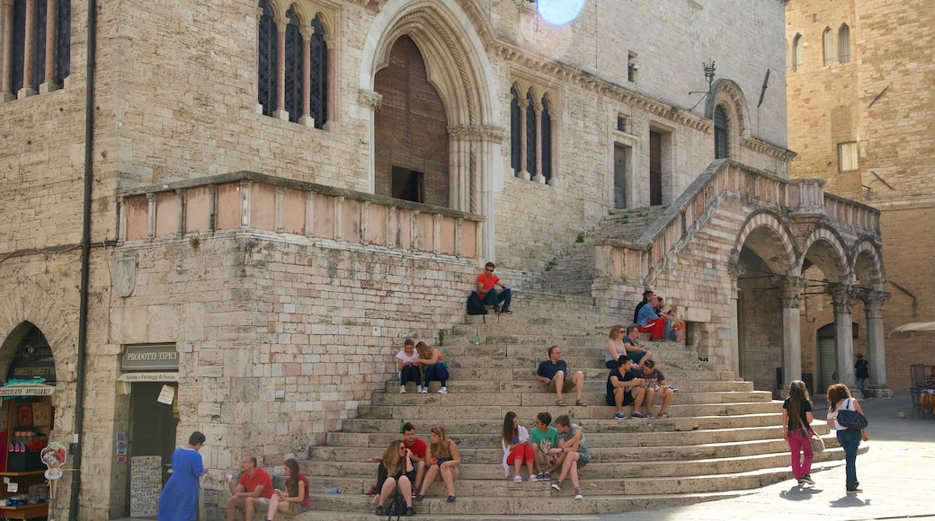 Palazzo dei Priori caratteristiche di architettura d\'epoca cosi come un grande gruppo di persone