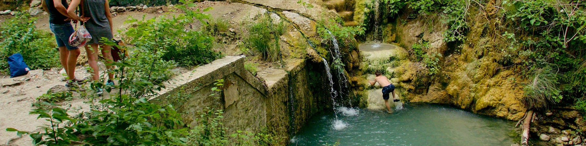 Bagni San Filippo mit einem See oder Wasserstelle und Schwimmen sowie kleine Menschengruppe