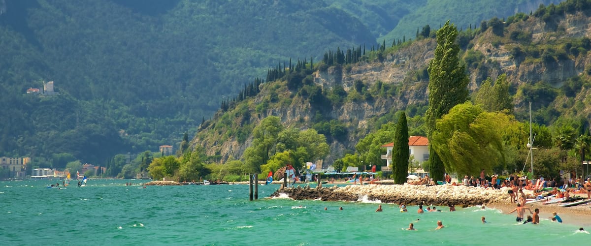 Nago-Torbole featuring a sandy beach, swimming and mountains