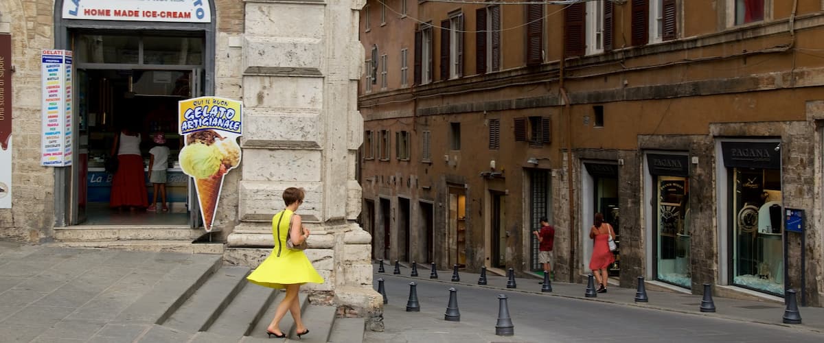 Piazza IV Novembre featuring heritage architecture and a city as well as a small group of people