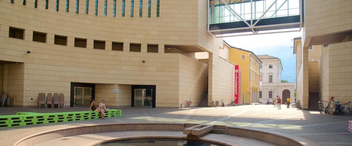 Museum of Modern and Contemporary Art showing a pond and modern architecture as well as a small group of people