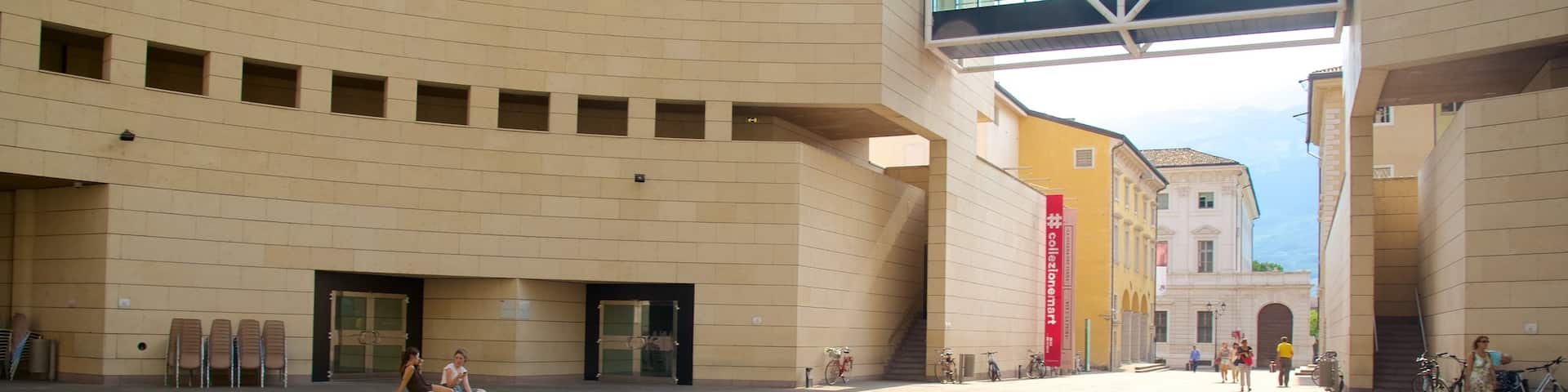 Museum of Modern and Contemporary Art showing a pond and modern architecture as well as a small group of people