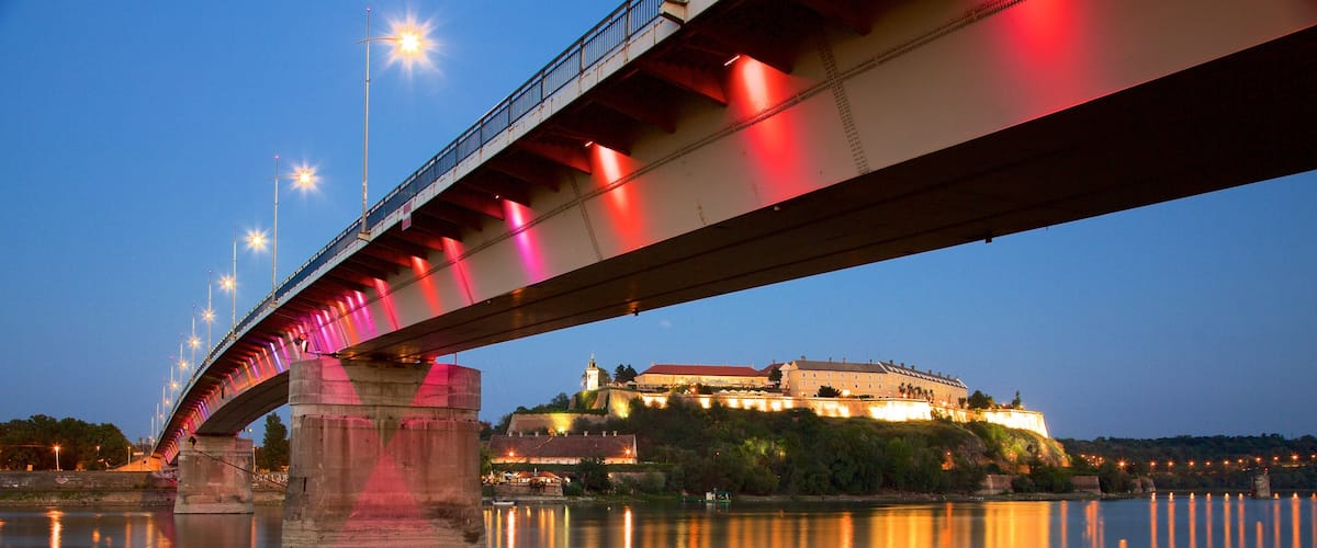 Petrovaradin Fortress which includes night scenes, a river or creek and a bridge