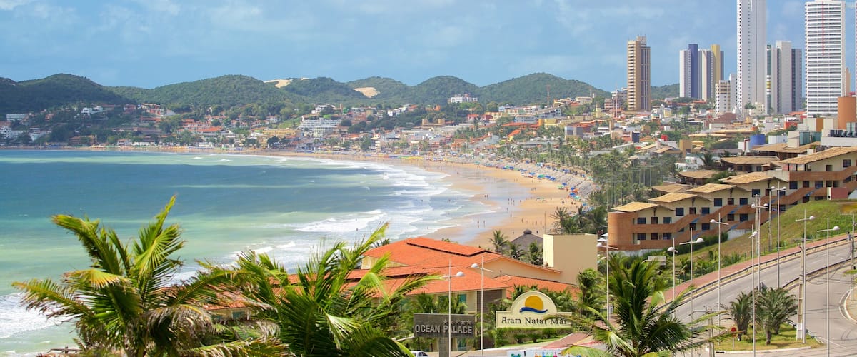 Praia de Ponta Negra mostrando uma praia de areia, uma cidade litorânea e um edifício