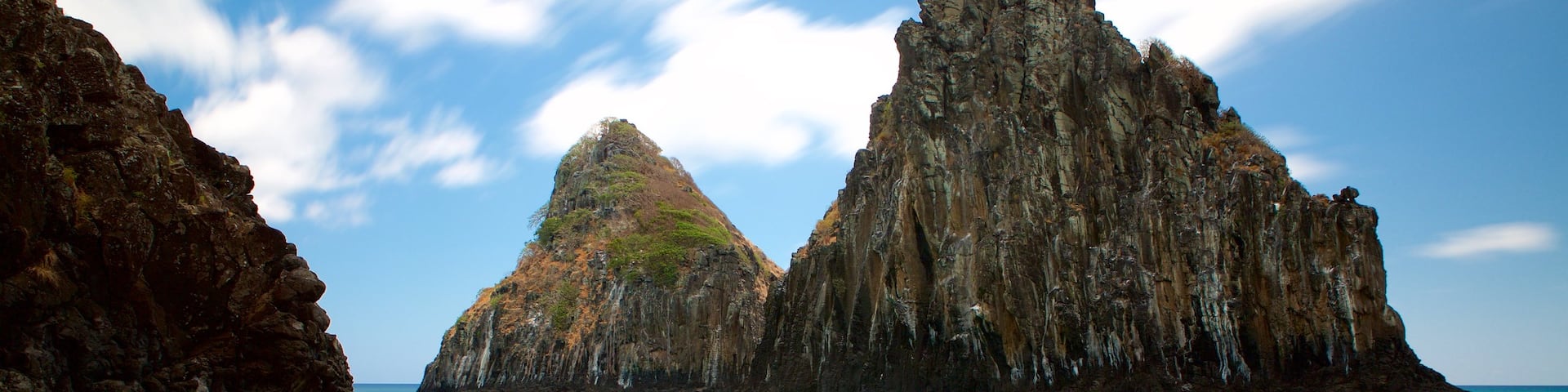 Dois Irmaos Hill which includes rocky coastline, a beach and general coastal views