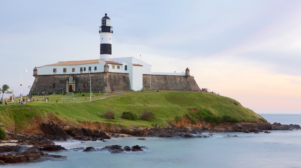 Playa Farol da Barra mostrando un faro, vistas generales de la costa y una puesta de sol