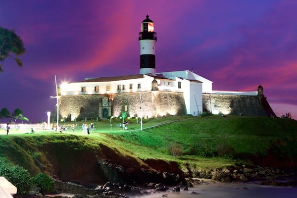 Plage de Farol da Barra mettant en vedette phare, coucher de soleil et scĂšnes de nuit