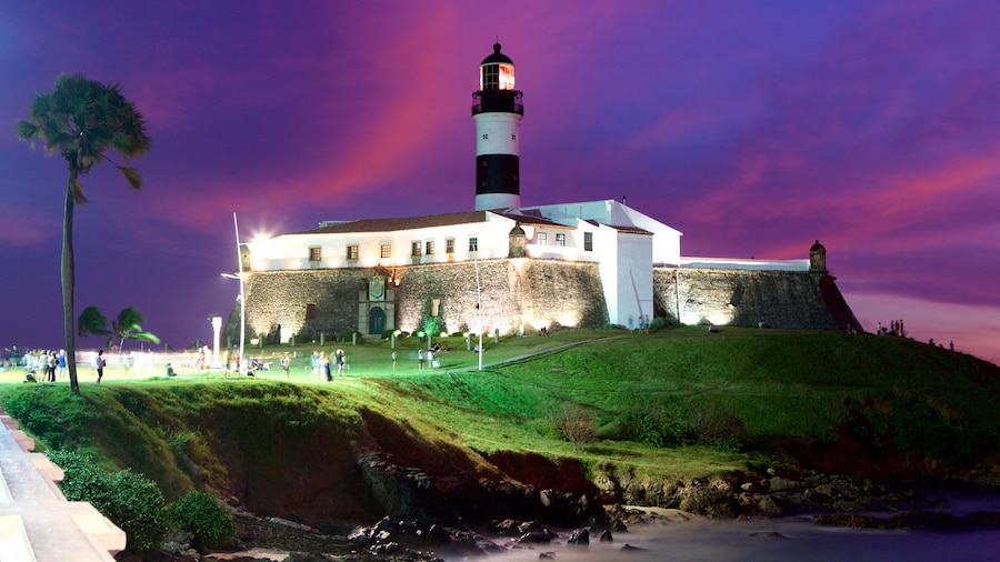 Farol da Barra Beach featuring a lighthouse, night scenes and a sunset