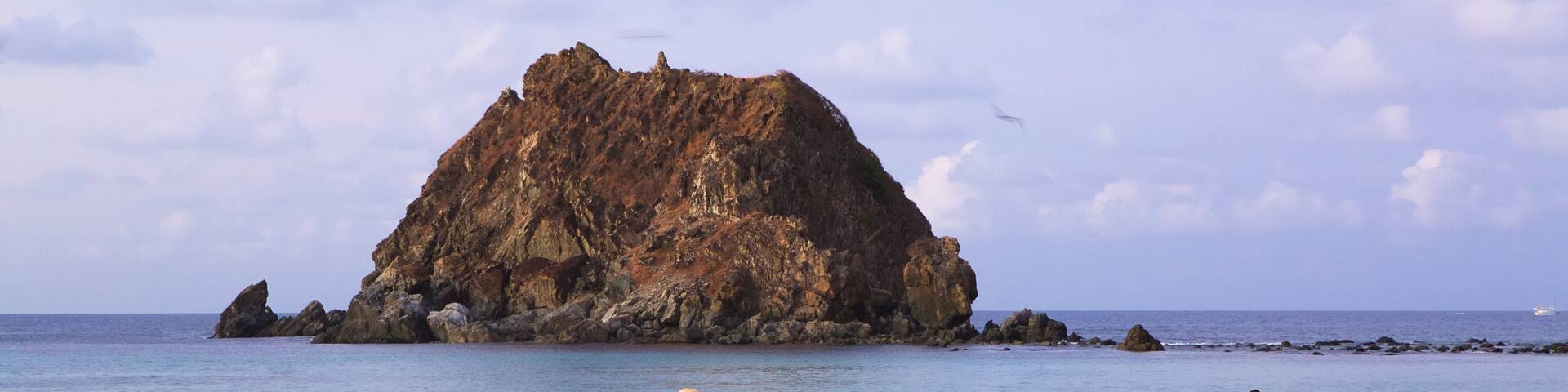 Conceicao Beach which includes general coastal views and a beach as well as a small group of people