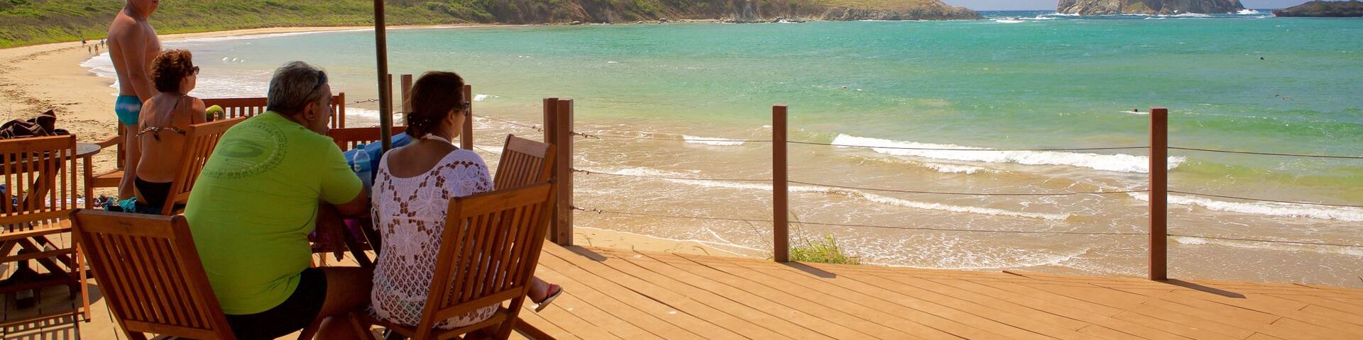Sueste Beach which includes waves, mountains and a luxury hotel or resort
