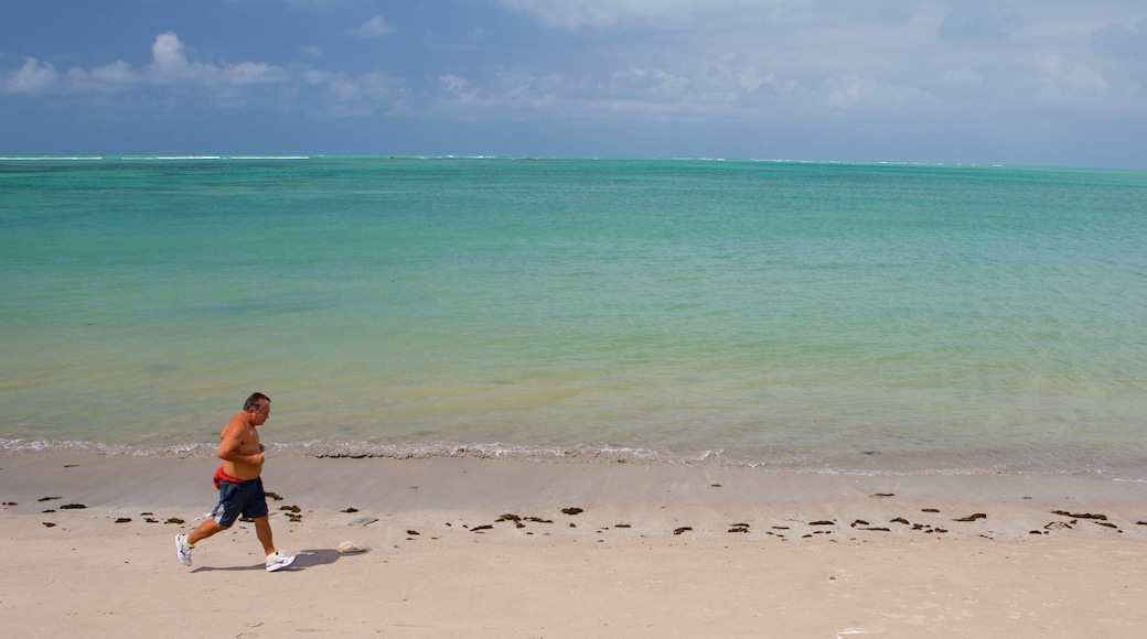 Ponta Verde Beach showing general coastal views and a beach as well as an individual male