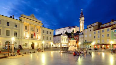 Piran mostrando piazza e paesaggio notturno cosi come un grande gruppo di persone