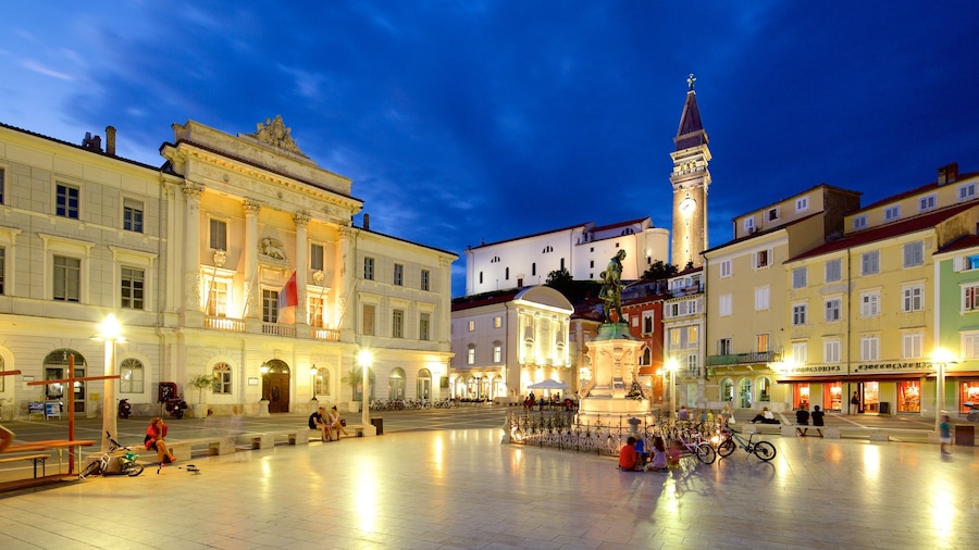 Piran ofreciendo escenas nocturnas y un parque o plaza y también un gran grupo de personas