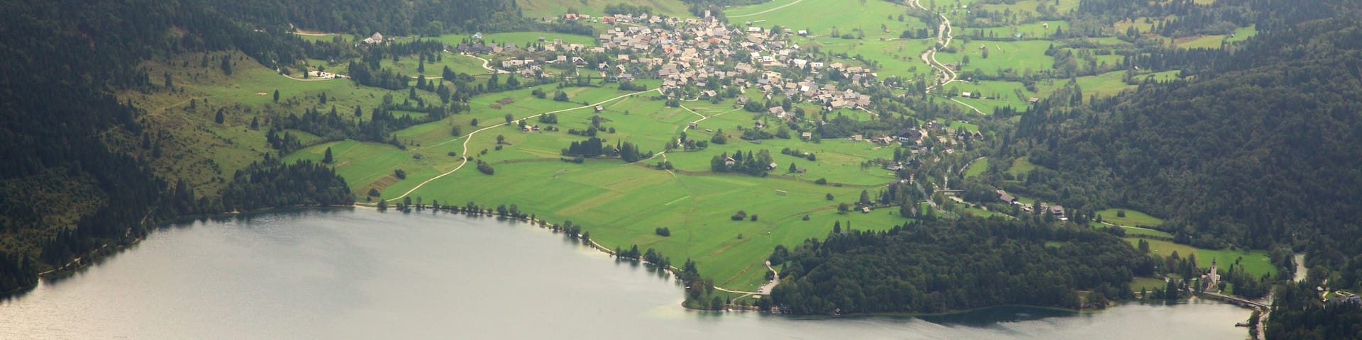 Triglav National Park showing a small town or village, mountains and a lake or waterhole