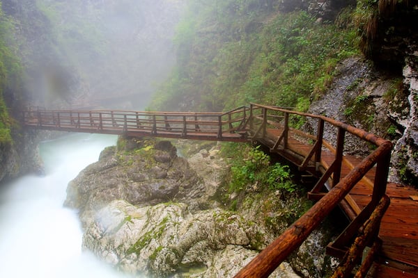 Vintgar Gorge which includes a gorge or canyon, mist or fog and a bridge