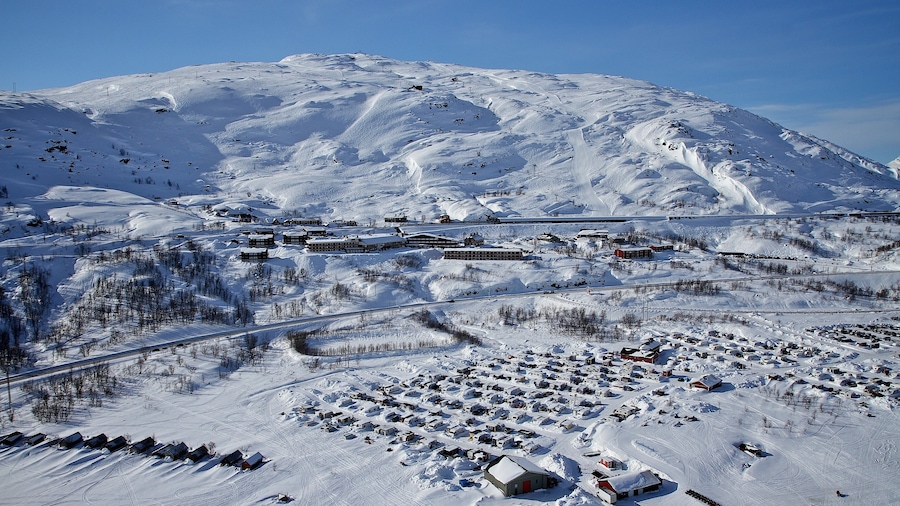Riksgransen que incluye nieve y una pequeña ciudad o pueblo