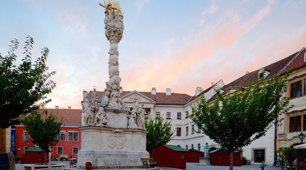 Sopron som inkluderar en solnedgång och ett monument