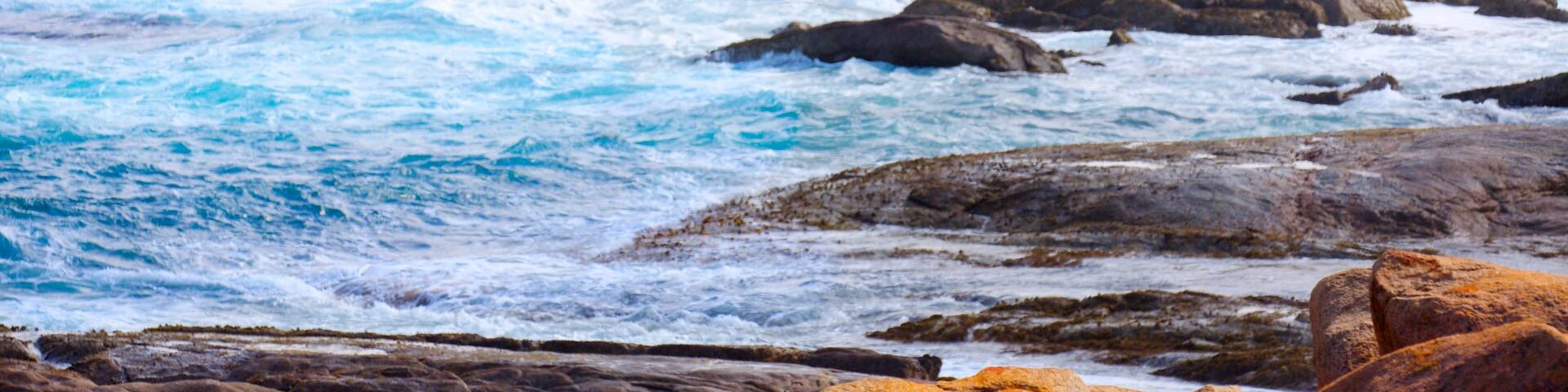 Cape Leeuwin Lighthouse featuring rocky coastline and surf