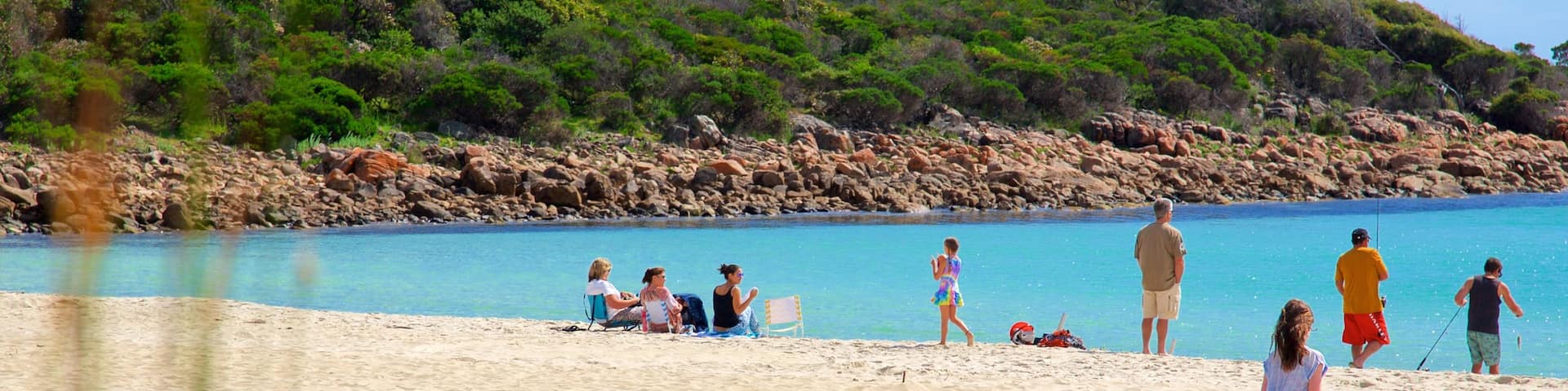 Naturaliste showing rugged coastline and a sandy beach as well as a small group of people