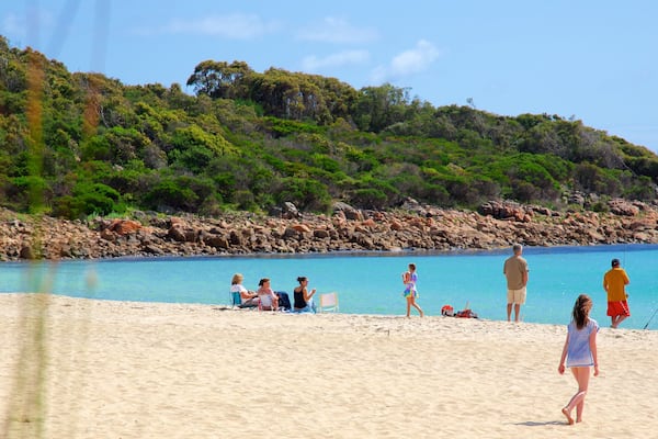 Naturaliste showing a sandy beach and rocky coastline as well as a small group of people