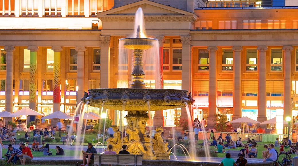 Schlossplatz featuring a fountain and night scenes as well as a large group of people