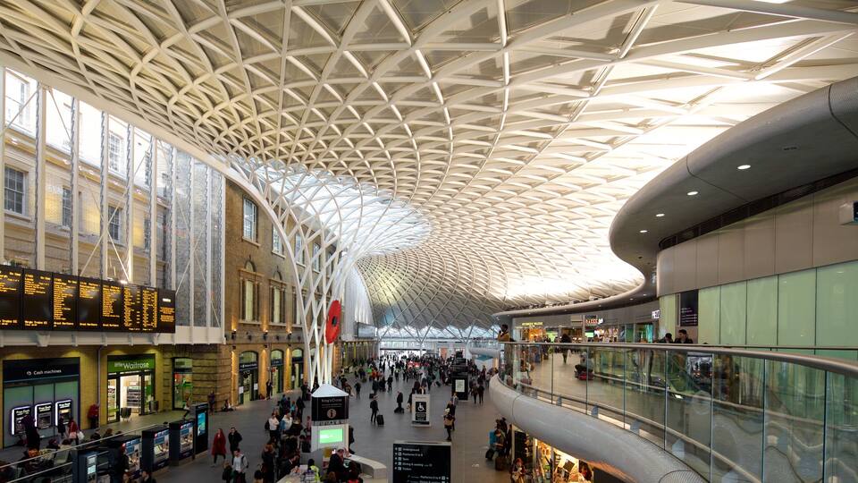 Kings Cross St. Pancras fasiliteter samt innendørs og moderne arkitektur i tillegg til en stor gruppe med mennesker