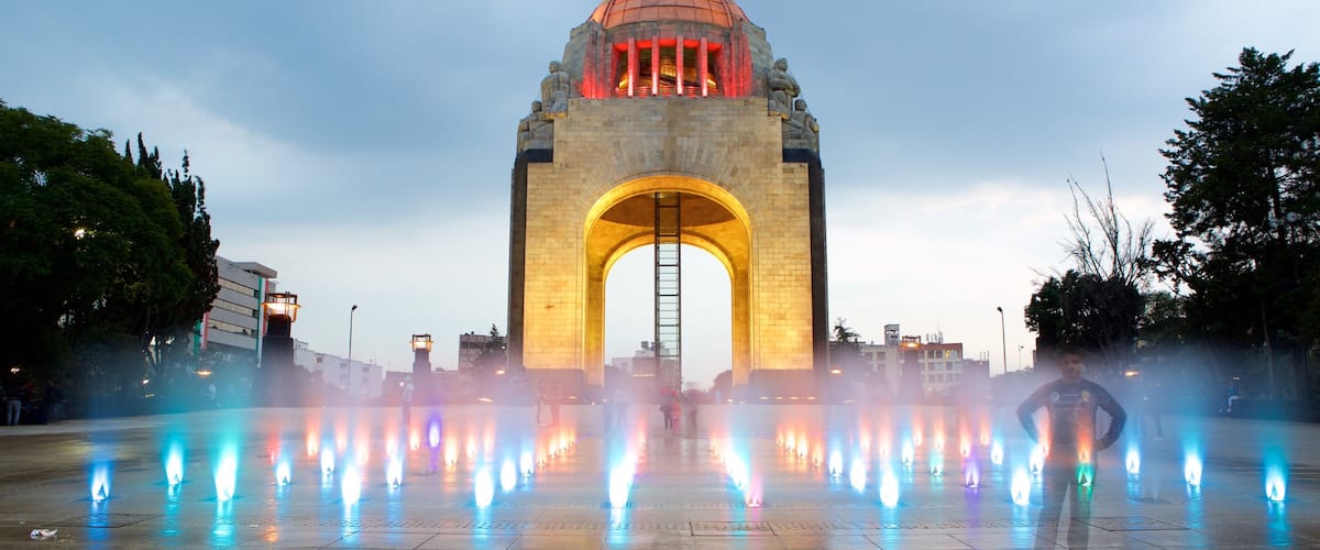 Monumento a la Revolución mostrando elementos del patrimonio, escenas nocturnas y un parque o plaza