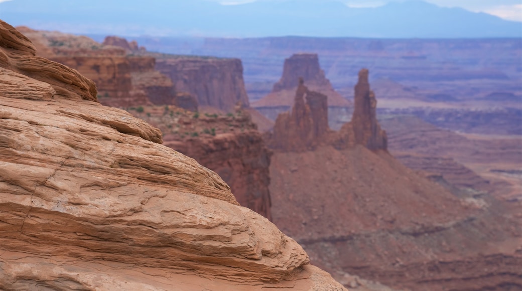 Mesa Arch Trail featuring tranquil scenes, mountains and a gorge or canyon