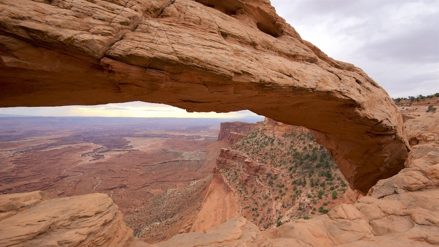 Mesa Arch Trail featuring a gorge or canyon, mountains and tranquil scenes