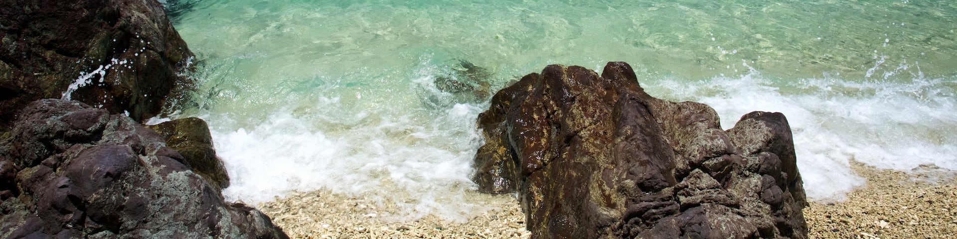 Daydream Island showing rugged coastline, a pebble beach and landscape views