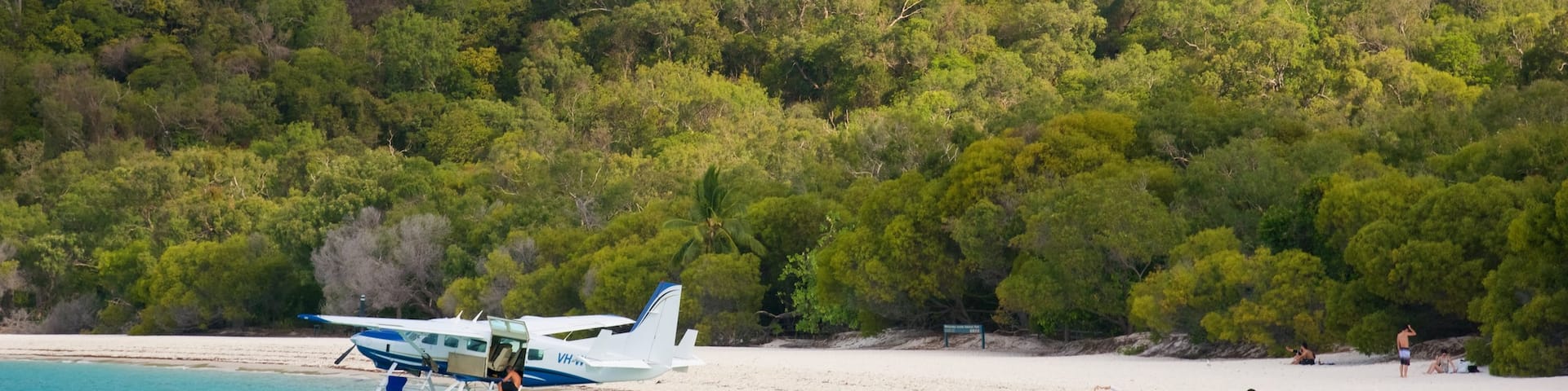 Hamilton Island showing aircraft, a sandy beach and tropical scenes