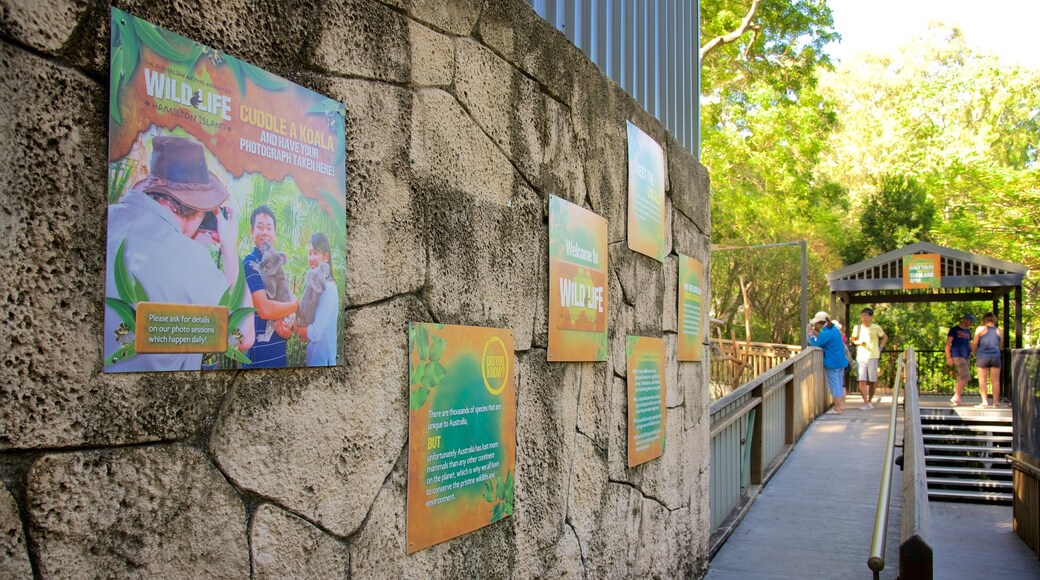 WILD LIFE Hamilton Island che include segnaletica cosi come un piccolo gruppo di persone