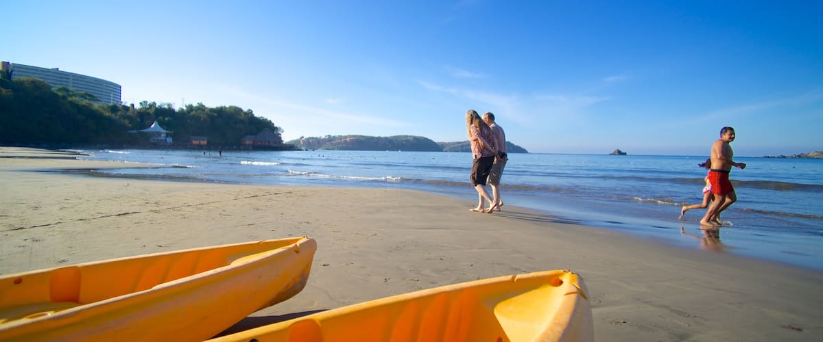 Playa Linda ofreciendo una playa de arena y vistas generales de la costa y también una pareja