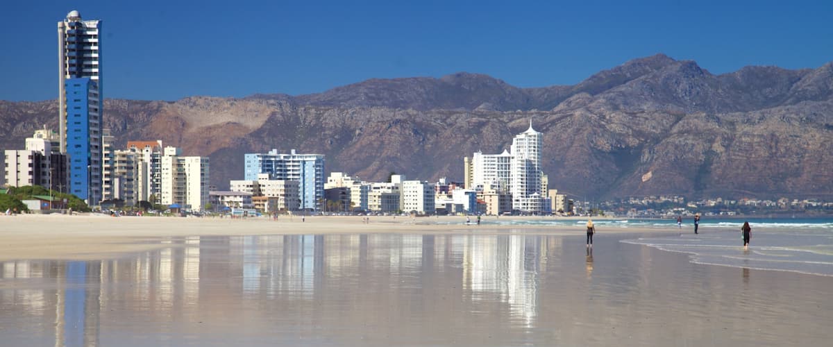 Strand showing a beach, landscape views and a city