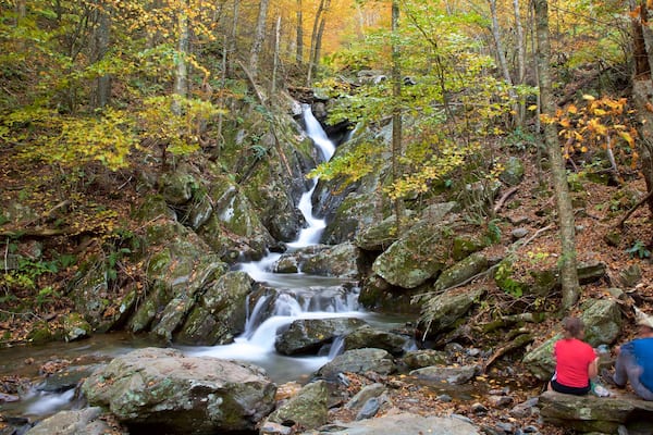 Parc national de Shenandoah qui includes rivière ou ruisseau et scènes forestières aussi bien que couple