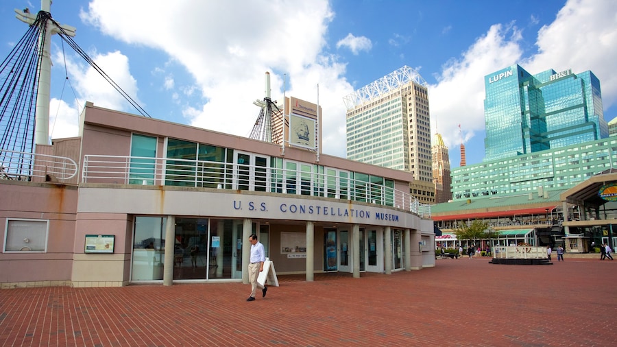 USS Constellation mostrando un edificio alto y una ciudad y también un hombre