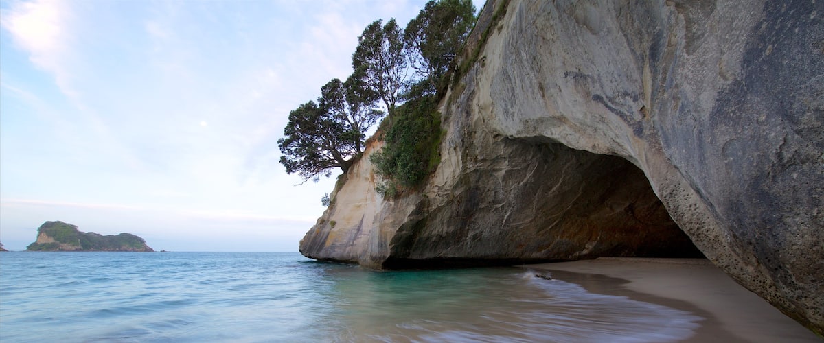 Península de Coromandel ofreciendo costa rocosa, una bahía o puerto y una playa de arena