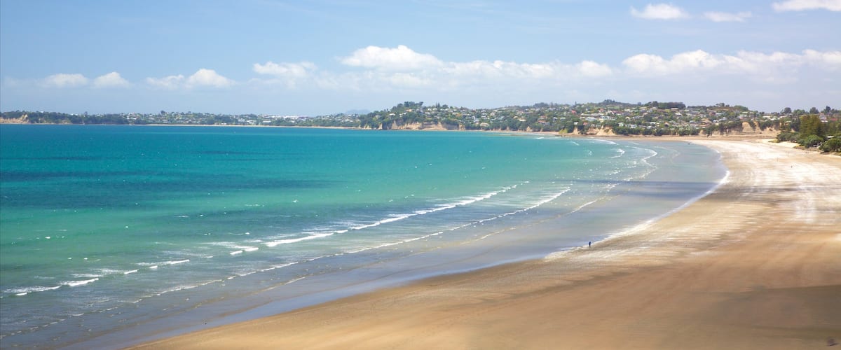 Orewa ofreciendo una playa y una bahía o puerto