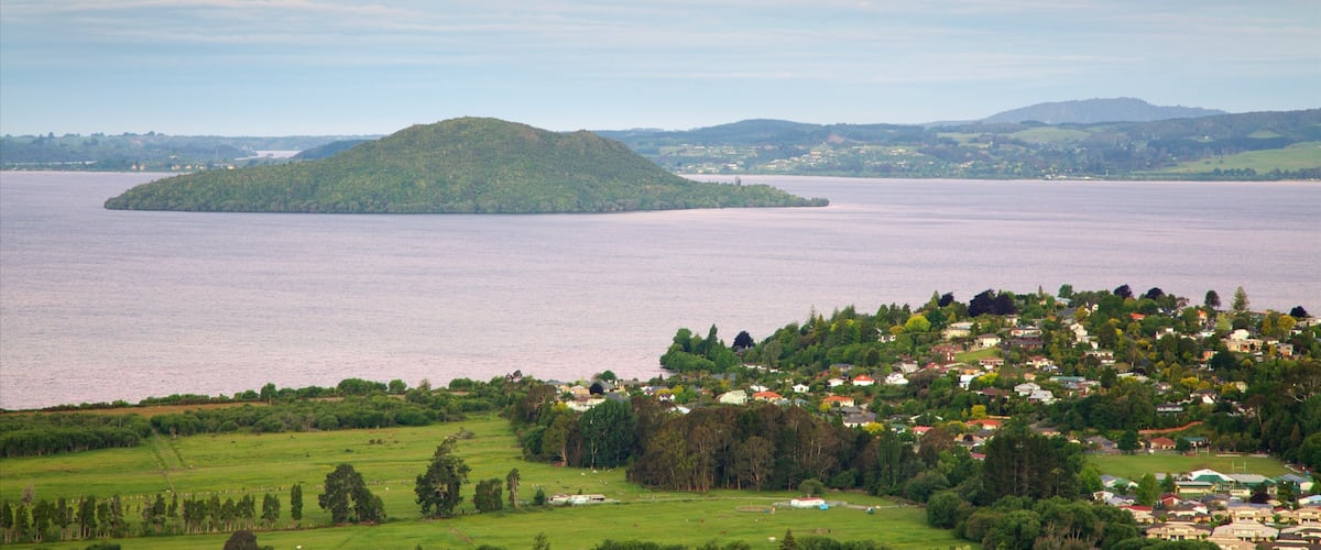 Mokoia Island caracterizando um lago ou charco, uma cidade pequena ou vila e um pôr do sol
