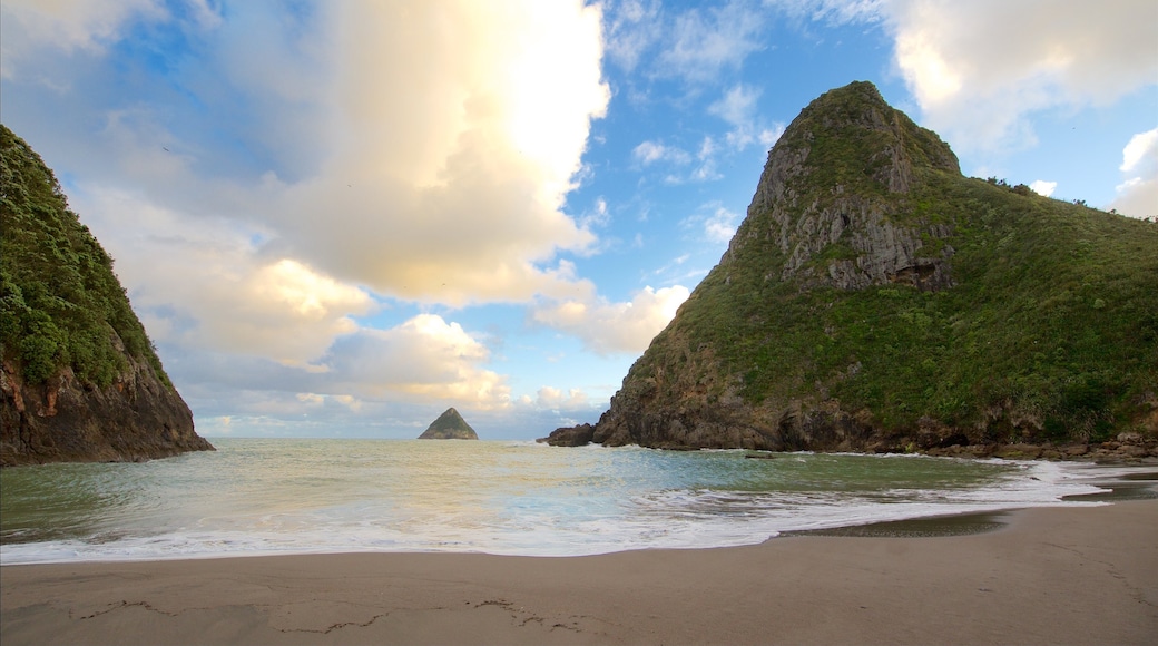 Paritutu Rock showing mountains, a sandy beach and a bay or harbour