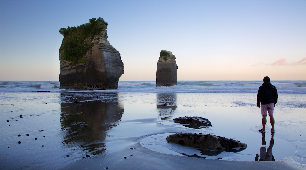 Tongaporutu que inclui uma baía ou porto, um pôr do sol e litoral rochoso