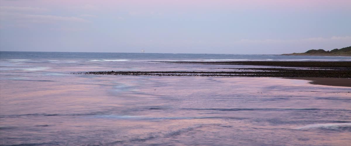 Fitzroy Beach featuring a bay or harbour and a sunset
