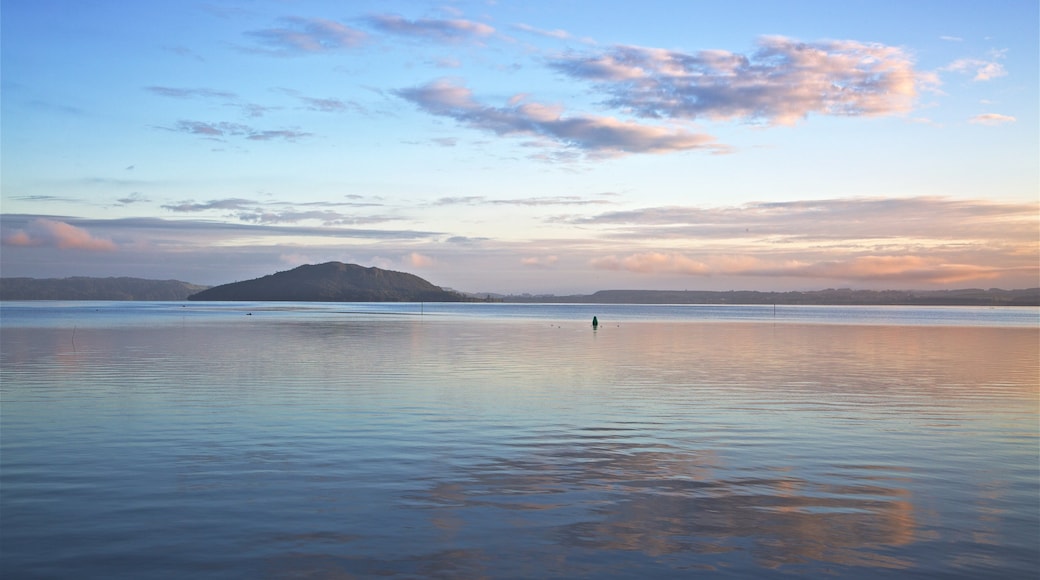 Mokoia Island which includes a lake or waterhole and a sunset